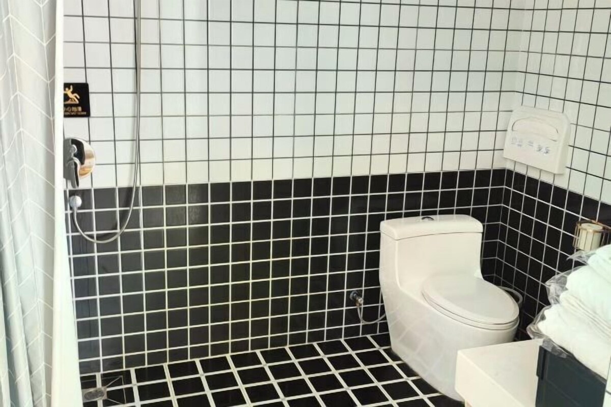 A bathroom with a toilet, a shower, and a sink.