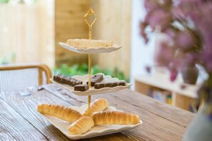 Een etagère met gebak en chocolade op een houten tafel.