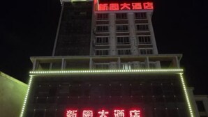 Ein Hotel mit auffälligem, roten Schild und beleuchteter Fassade.
