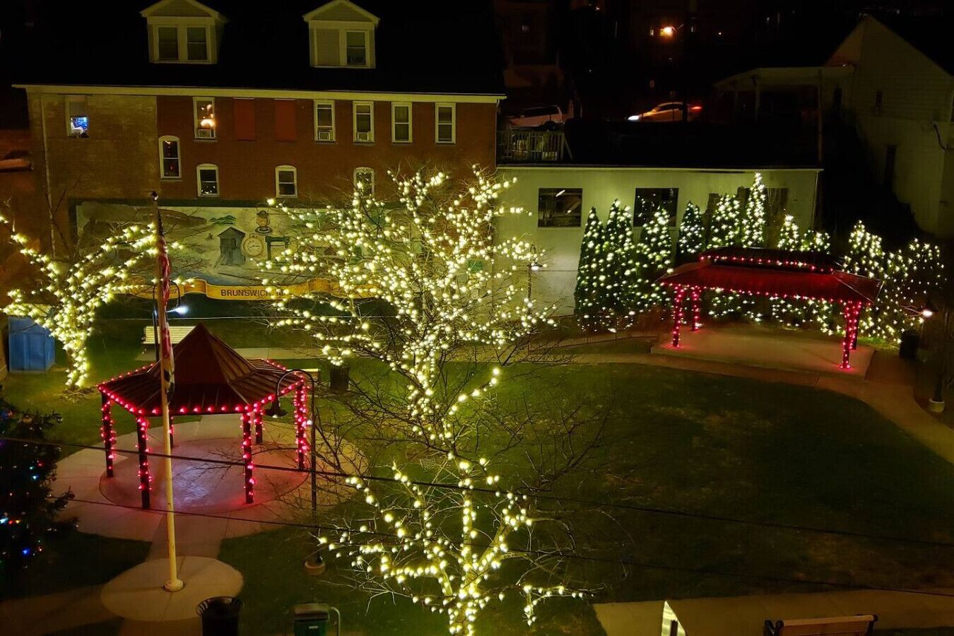 A courtyard with illuminated trees and a gazebo.