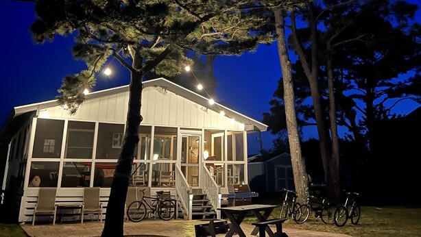A house with a porch and a covered patio area. - Waterfront Harbor Home, Sunset Views, Fireplace, Private dock and Boat Slip (Kill Devil Hills)
