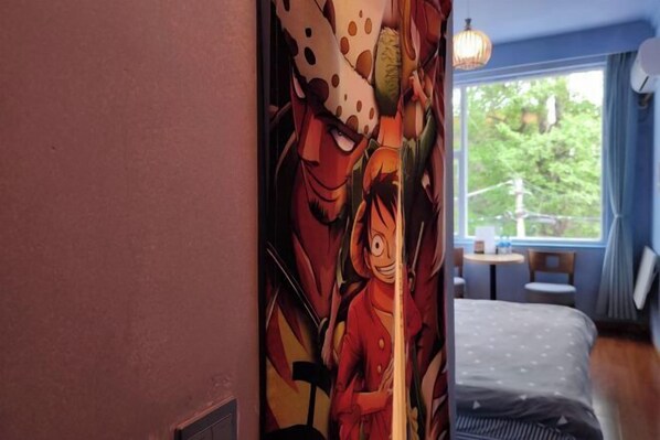 A bedroom with a bed, a window with a view of greenery, and a wall with a colorful mural. - V-Hostel (Dali City)