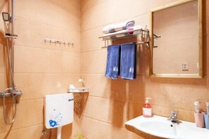 A bathroom with a shower, a sink, and a towel rack. - V-Hostel (Dali City)