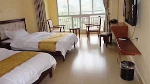 A hotel room with two beds, a desk, a chair, a TV, and a balcony.