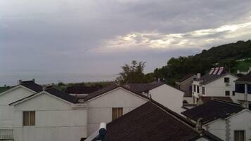 A residential area with houses, some with visible balconies, under a cloudy sky.