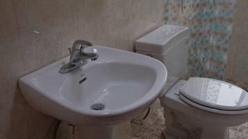 Une salle de bain avec un lavabo et des toilettes.
