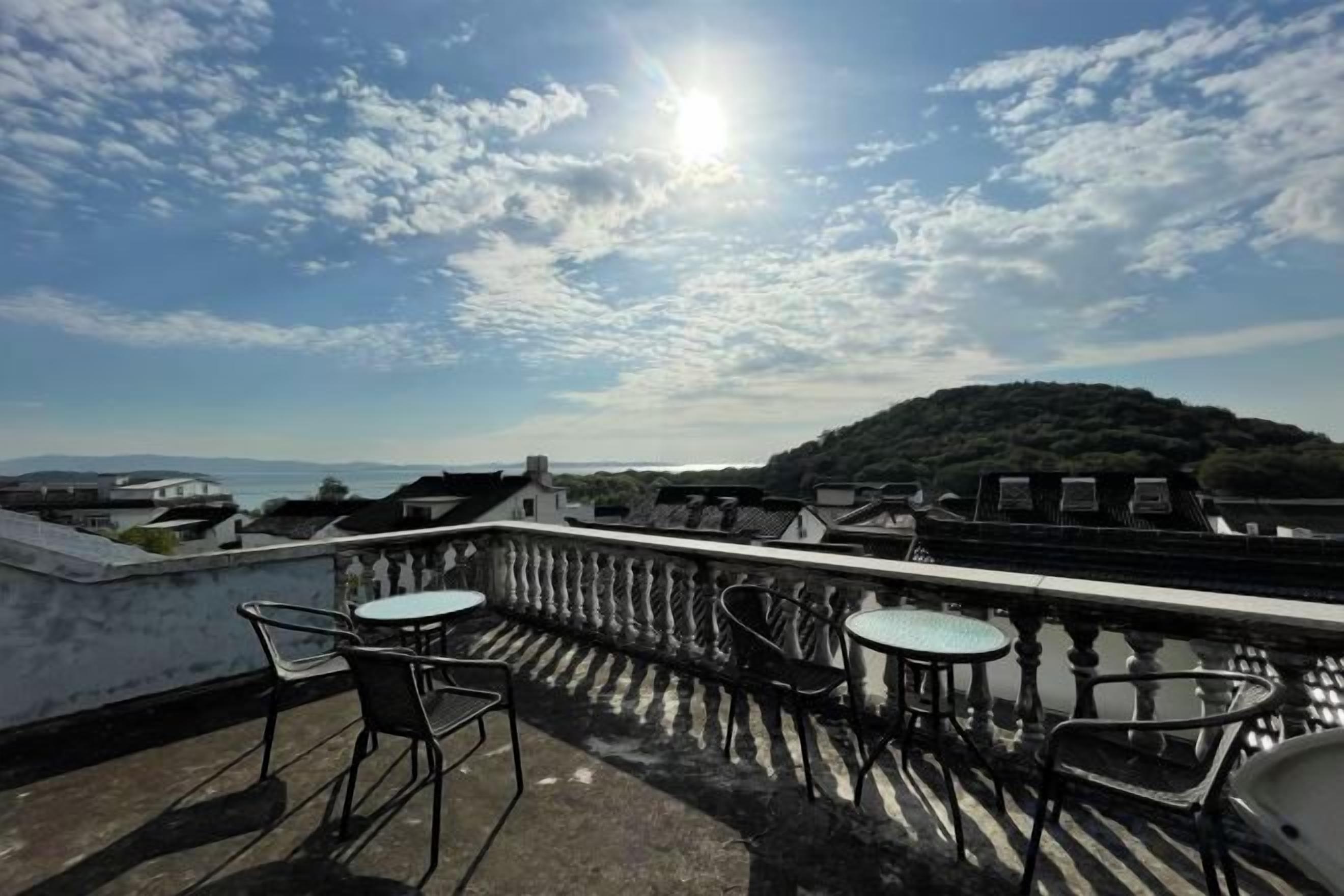 Une terrasse avec des sièges extérieurs et une vue sur une colline.