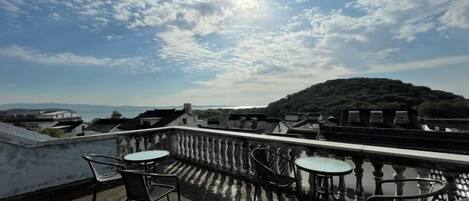 Una terraza con asientos al aire libre y vistas a una colina.