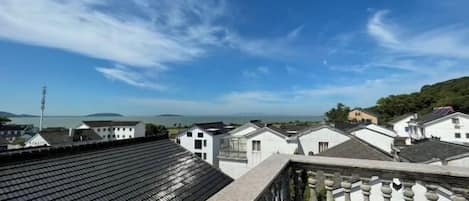 A view of a residential area with white houses, a clear blue sky, and distant mountains.