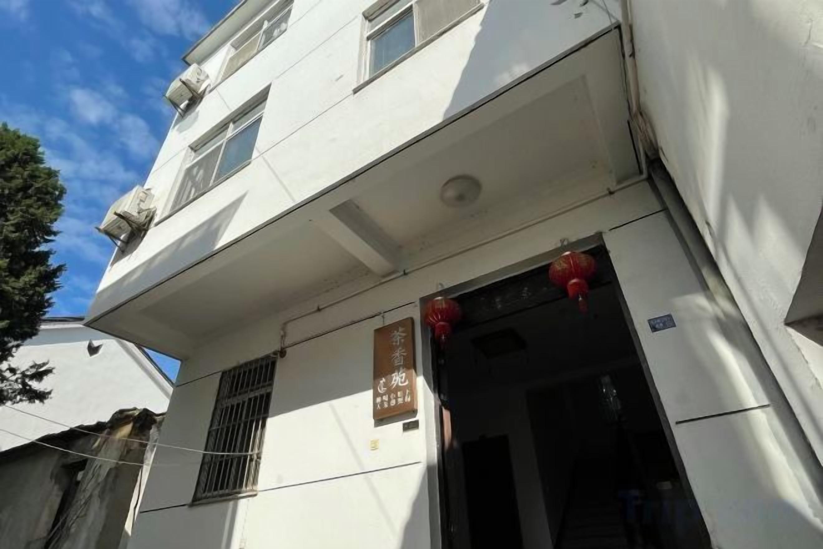 A building with a sign indicating a business or service establishment on the ground floor.