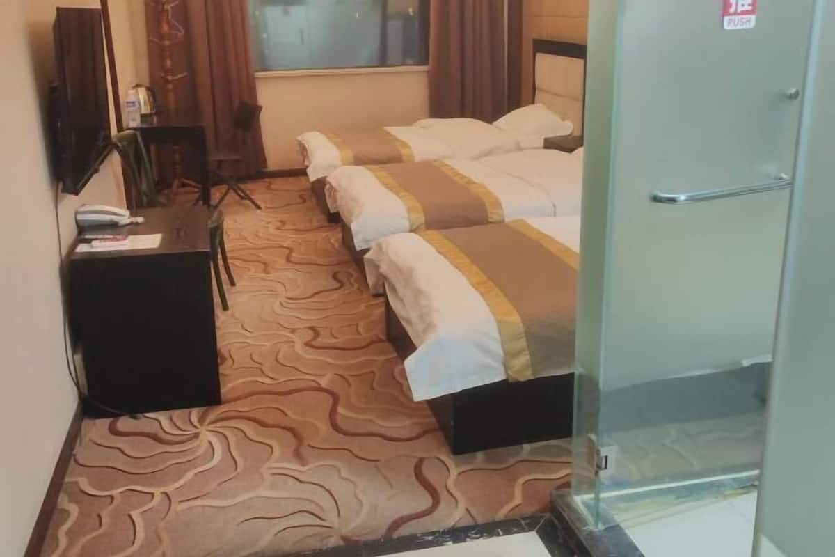 A hotel room with two beds, a desk with a telephone, a mirror, and a door with a push sign.