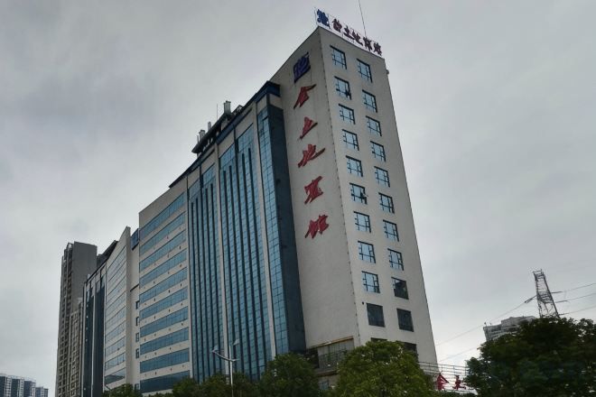 A multi-story building with a prominent vertical sign on the side.