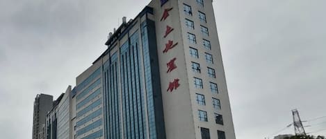 A multi-story building with a prominent vertical sign on the side.