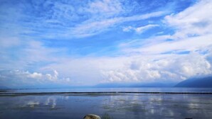 A calm body of water with a clear sky and distant land. - Shanshui Qingju Inn (Dali City)