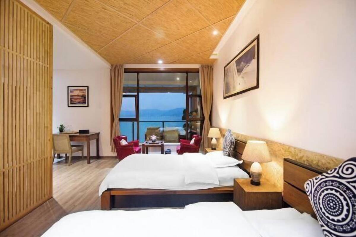 A hotel room with a bed, bedside tables, a desk, and chairs.