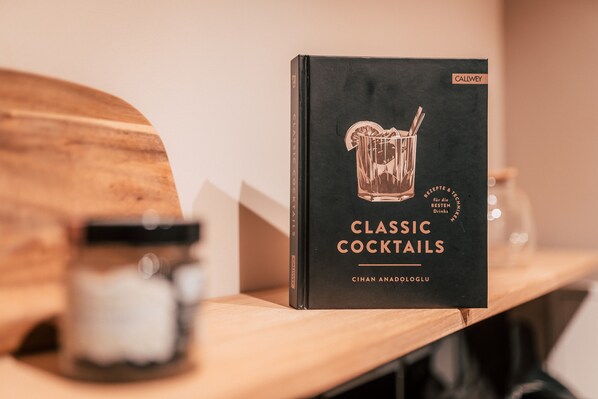 A book titled "Classic Cocktails" by Cihan Anadoluglu on a wooden shelf. - Luga Homes - Nikolaikirche (Leipzig)