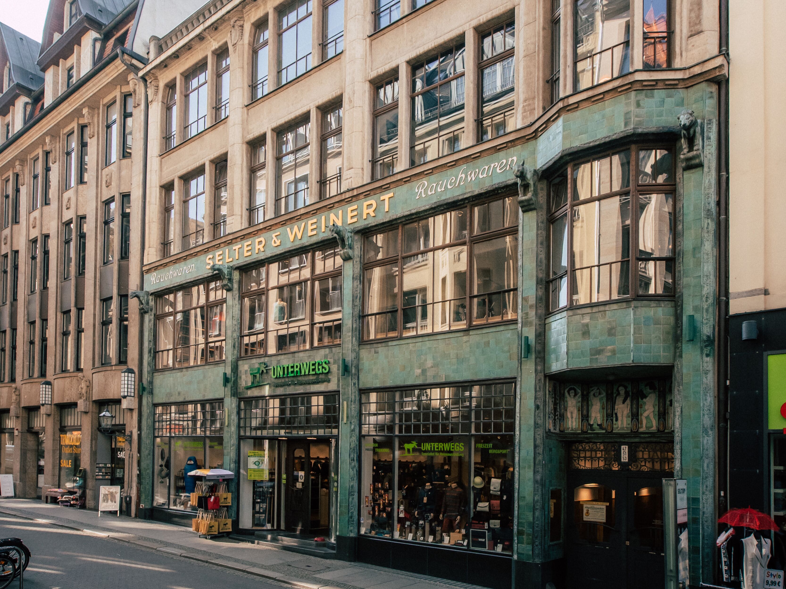 A historic building with multiple storefronts, including a visible sign for 'Unterwegs' and 'Rauchwaren'.
