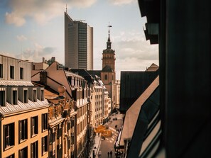 A cityscape with historic buildings and a modern skyscraper. - Luga Homes - Nikolaikirche  (Leipzig)