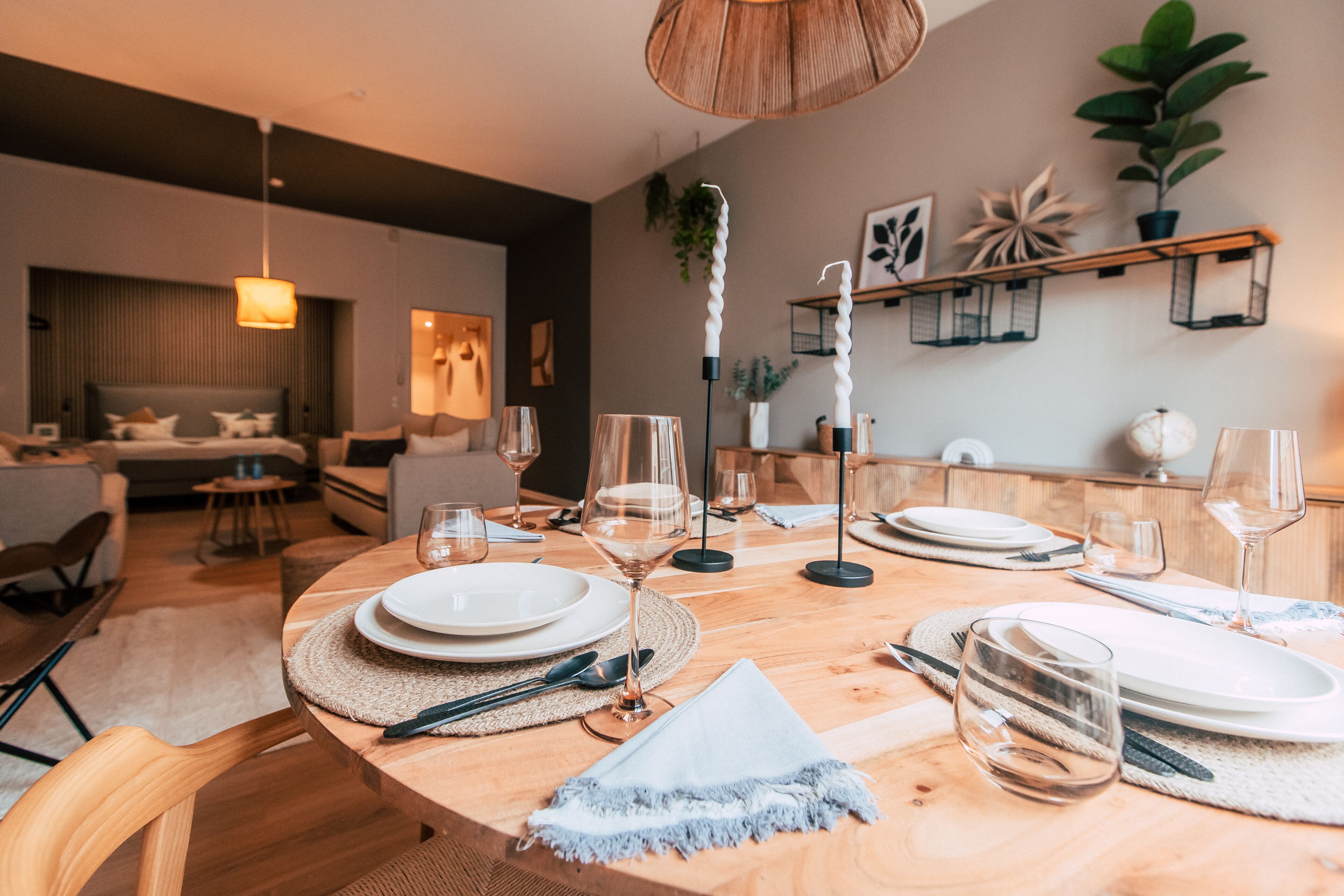 A dining area with a wooden table set for six, surrounded by chairs.