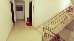 Un pasillo con una escalera que sube a un piso superior.