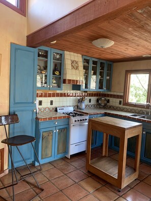 Kitchen with a rustic charm, featuring a gas stove, sink, and wooden table.