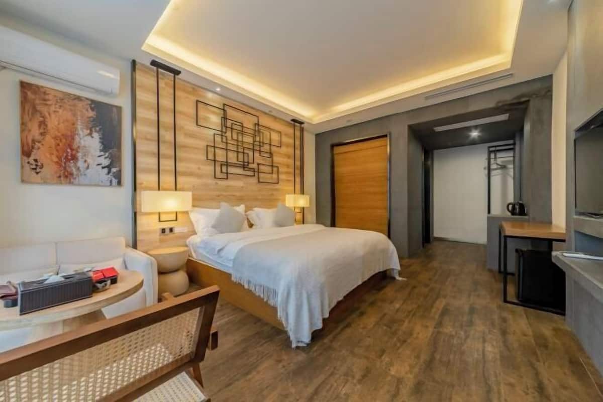 Une chambre d’hôtel moderne équipée d’un lit, de tables de chevet, d’un bureau et d’une chaise.