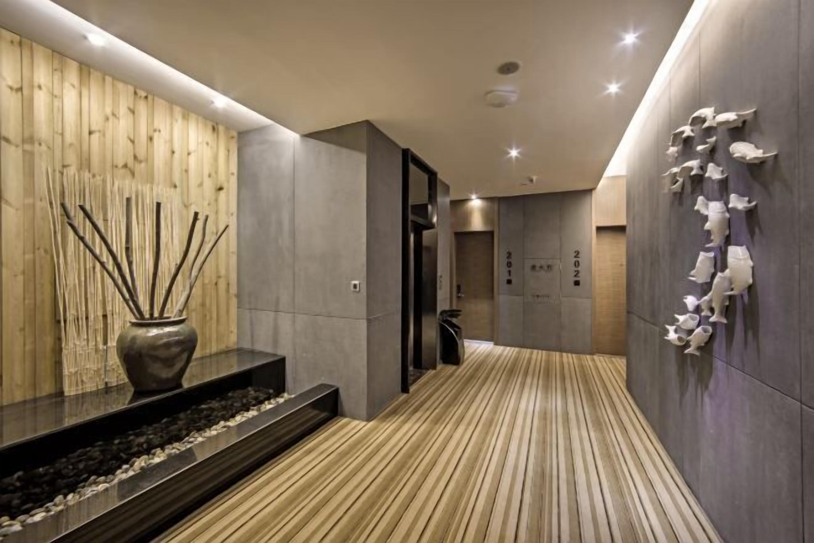 A modern interior with a wooden wall, a black vase, and a patterned floor.