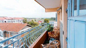 Ein Balkon mit Blick auf benachbarte Gebäude und einen klaren Himmel.
