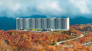 A multi-story hotel with a modern design, located on a hill with autumn foliage. - Altitude Adjustment - King bed, Gig-Speed Internet, Mountain View, Ski (Sugar Mountain)