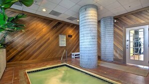 A spa area with a rectangular hot tub, wooden walls, and two large stone pillars. - Altitude Adjustment - King bed, Gig-Speed Internet, Mountain View, Ski (Sugar Mountain)