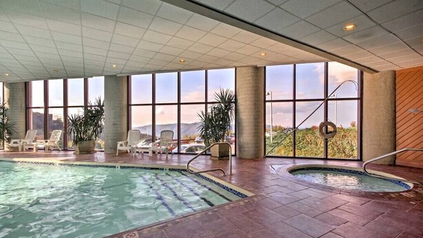 An indoor swimming pool with clear views of the surrounding landscape through large windows. - Altitude Adjustment - King bed, Gig-Speed Internet, Mountain View, Ski (Sugar Mountain)