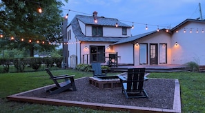 Een huis met een patio, een zithoek en een barbecue.