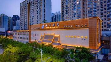 A modern building with a prominent entrance and signage, surrounded by high-rise residential buildings.