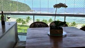 A dining area with a table, chairs, and a view of the ocean.