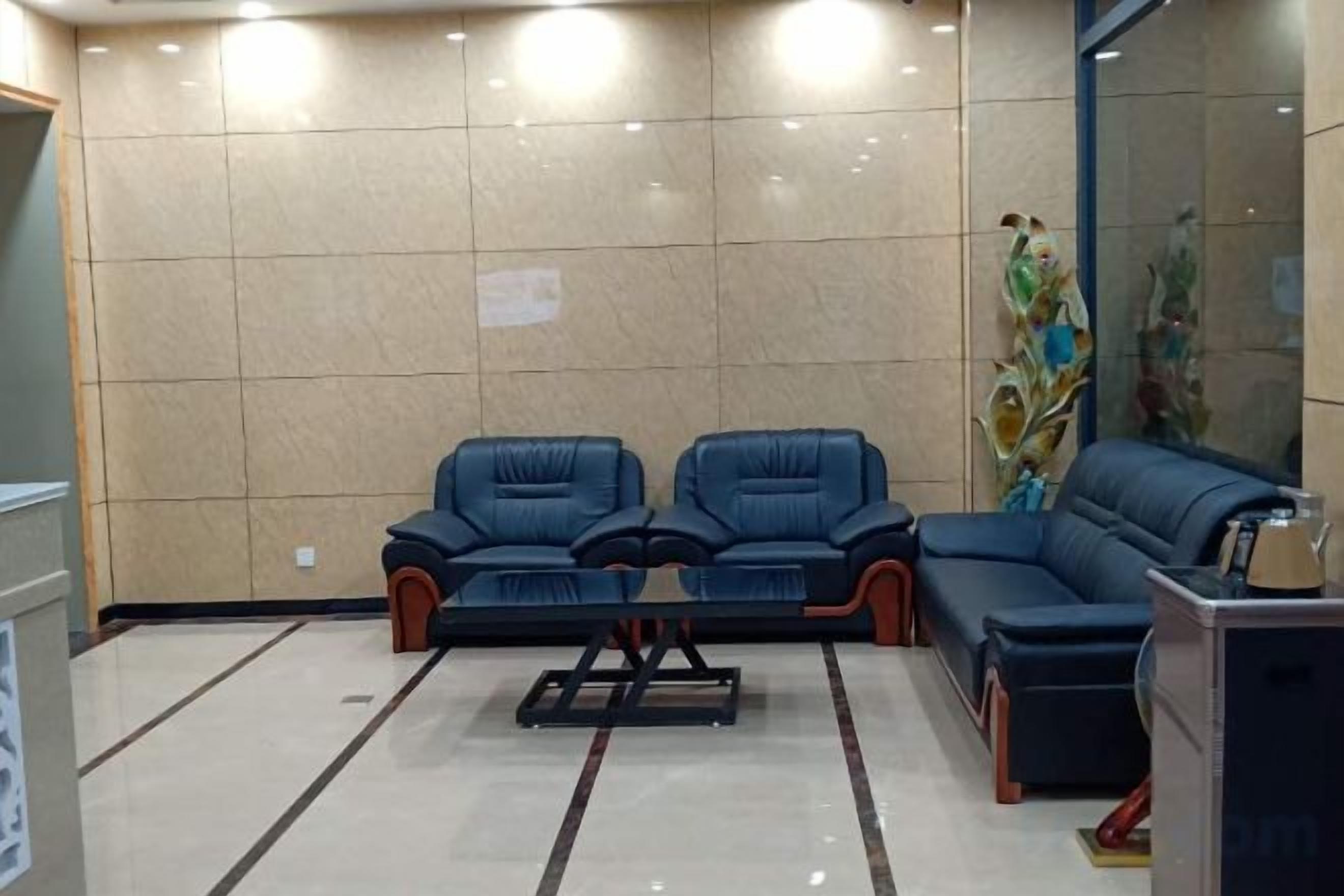 Una habitación con dos sofás azules, una mesita y un espejo grande.