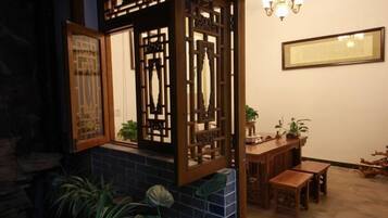 A traditional room with a wooden partition, a dining table, and a chandelier.