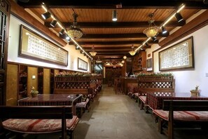 A traditional inn with wooden beams, multiple seating areas, and framed calligraphy on the walls. - Dongshan Courtyard Inn (Chengdu)