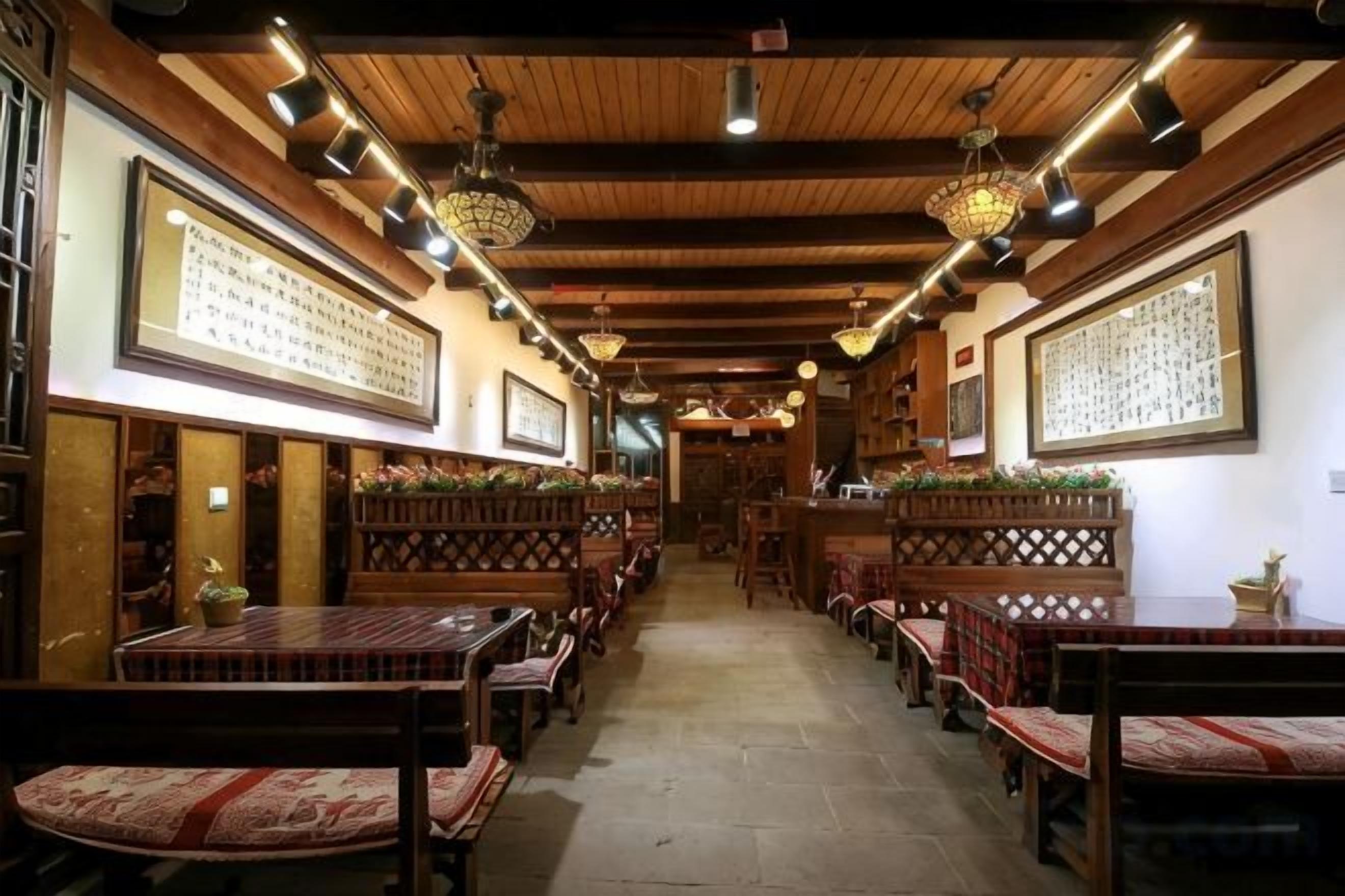 A traditional inn with wooden beams, multiple seating areas, and framed calligraphy on the walls.