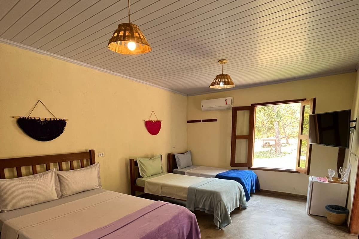 Una habitación con dos camas, un televisor y una ventana.