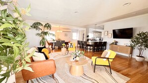 A modern living room with a dining area, a kitchen, and a TV. - 🏡 Joyful Vacation Home 🏡  (Anaheim)