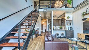 Un interior moderno con una escalera, un sofá de cuero, un comedor y una cocina.