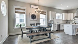 A modern kitchen with a dining area, featuring a large island, built-in appliances, and a chandelier. - Inlet Beach Cottage: Close to Beach Access! (Inlet Beach)