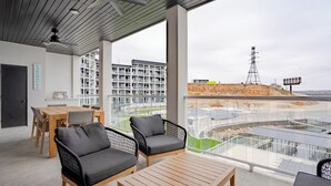 A modern hotel room with a balcony, a dining area, and a view of a building and power lines.