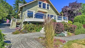 A two-story house with a balcony, surrounded by a landscaped garden and trees. - Direct Beach Access: Getaway on Port Orchard! (Bremerton)