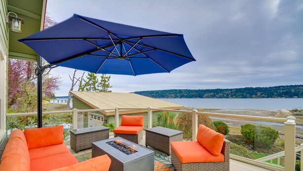 A deck with outdoor furniture, a fire pit, and a view of the water. - Direct Beach Access: Getaway on Port Orchard! (Bremerton)