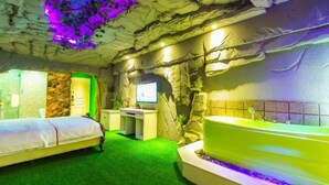 Una habitación con cama, escritorio, computadora y bañera.