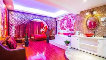 A room with a red and pink color scheme, a reception desk, a mirror, and a plant.