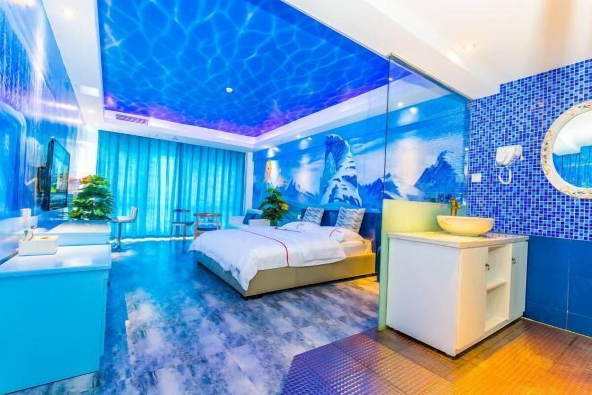 Un dormitorio moderno con una cama, un tocador y un ventanal grande.
