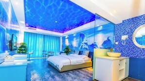 Un dormitorio moderno con cama, tocador con espejo y baño con lavabo e inodoro.