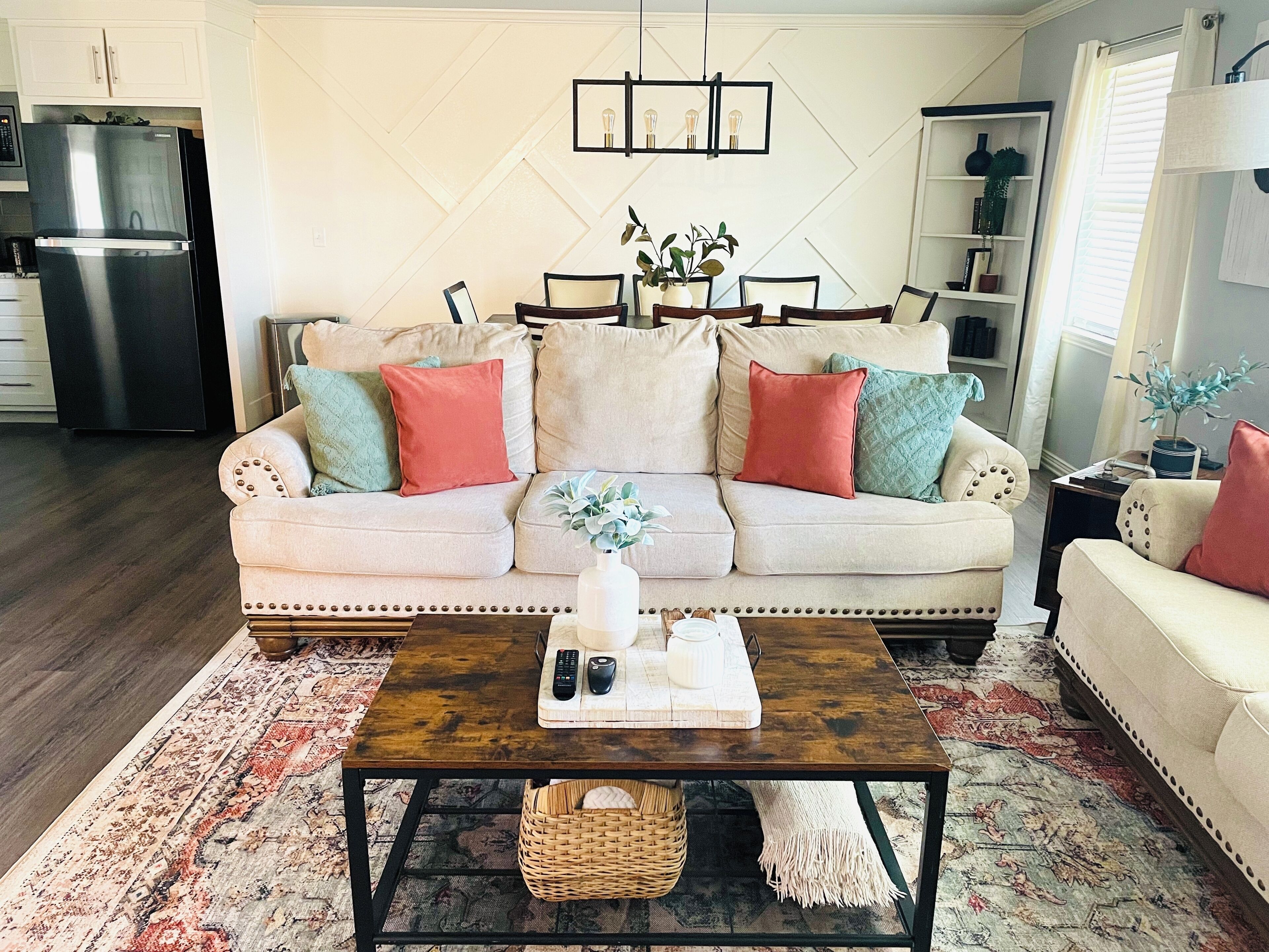 A living room with a beige sofa, a coffee table, and a patterned rug.
